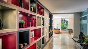 A modern interior with a red and black shelving unit displaying various decorative items and a polished marble floor. - Lummina Ibirapuera São Paulo (Sao Paulo)