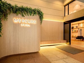 A hotel entrance with a wooden facade, a sign reading 'Mercure Hotel,' and a reception desk. - Mercure Sao Paulo Moema Times Square (São Paulo)