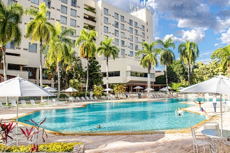 Una piscina al aire libre, sombrillas, sillones reclinables de piscina. Hotel Estelar Altamira