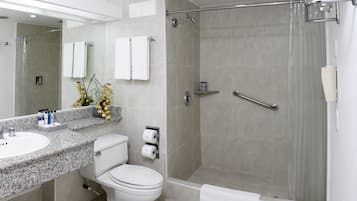 Een moderne badkamer met een douche, toilet en wastafel.