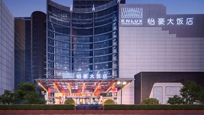 A modern hotel with a curved facade, large windows, and a prominent ENLUX sign. - ENLUX HOTEL  (Jinan)