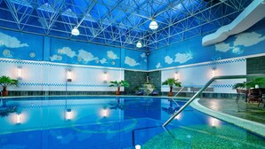 An indoor swimming pool with a blue mosaic ceiling, clear water, and a few potted plants. - ENLUX HOTEL  (Jinan)