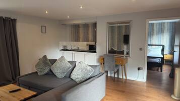 Suite superior, 1 cama matrimonial | Área de sala de estar | Televisión de 22 pulgadas con canales digitales