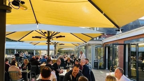 An outdoor dining area with yellow umbrellas, wooden tables, and chairs. - The Oaklands Hotel (Norwich)
