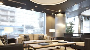 A modern hotel lobby with a central coffee table, sofas, and a lamp. - Hotel Barcelona Universal (Barcelona)