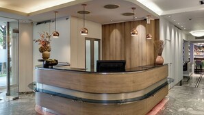 Un mostrador de recepción moderno con diseño curvo, paneles de madera y una superficie de vidrio.
