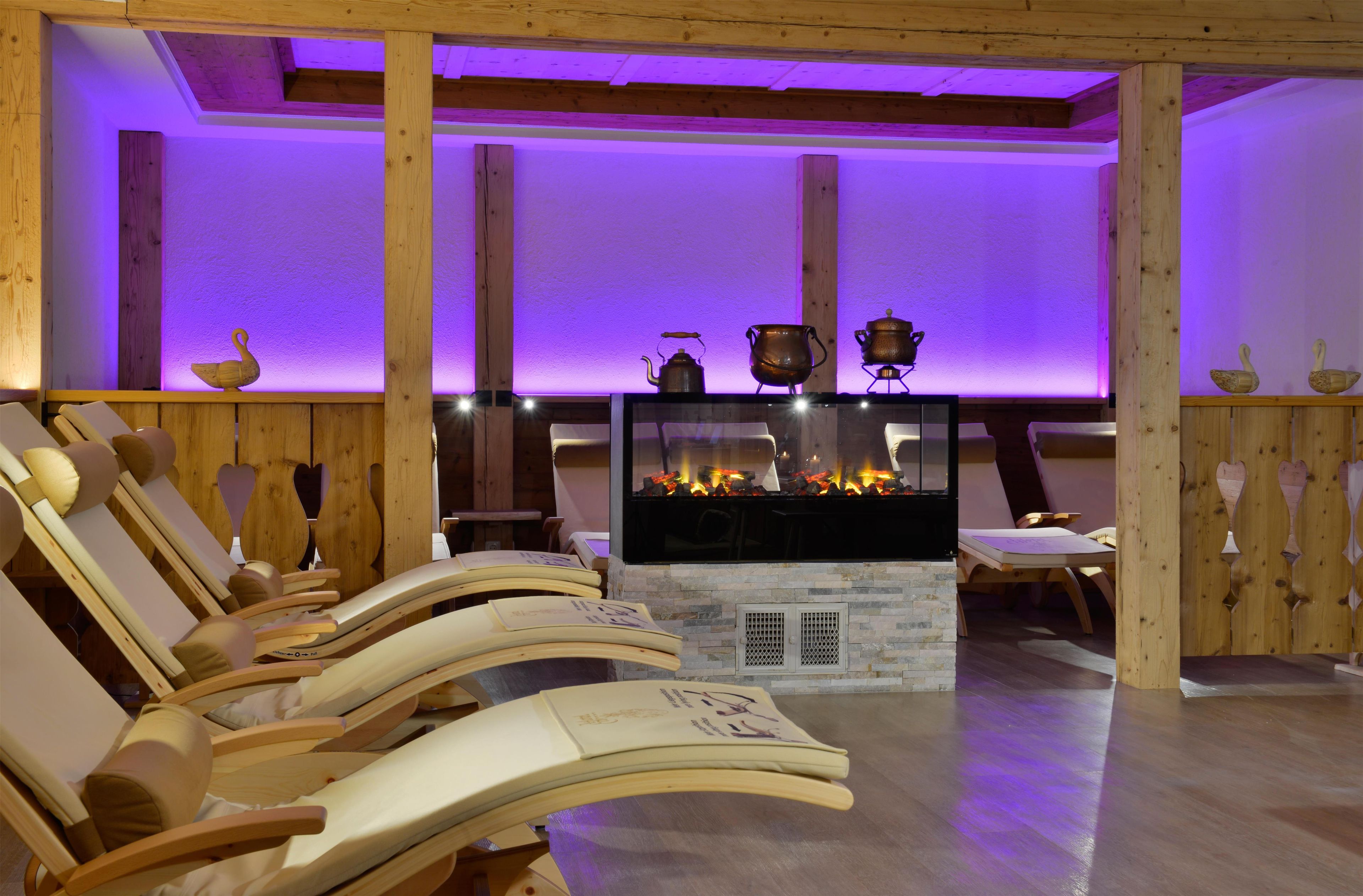 Una habitación con muebles de madera, chimenea e iluminación morada.