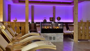 Una habitación con muebles de madera, chimenea e iluminación morada.
