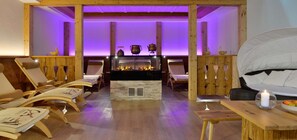 A spa room with wooden furniture, a fireplace, and a bed. - Best Western Plus Hotel Erb (Vaterstetten)