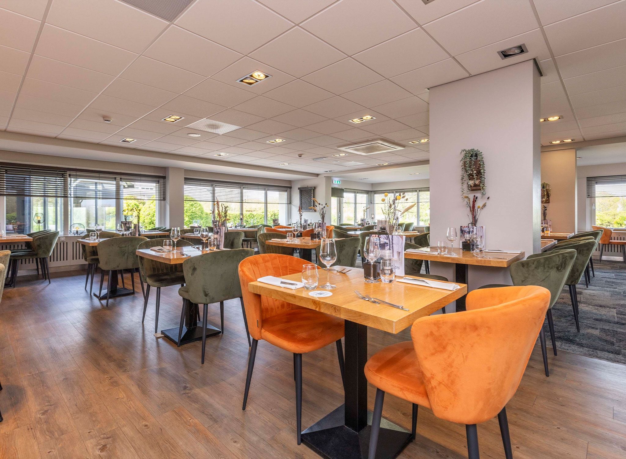 Un vaste espace dédié à la salle à manger, avec de nombreuses tables et chaises, de grandes fenêtres et un intérieur propre et moderne.