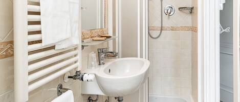 A bathroom with a bathtub, a sink, a shower, and a toilet.