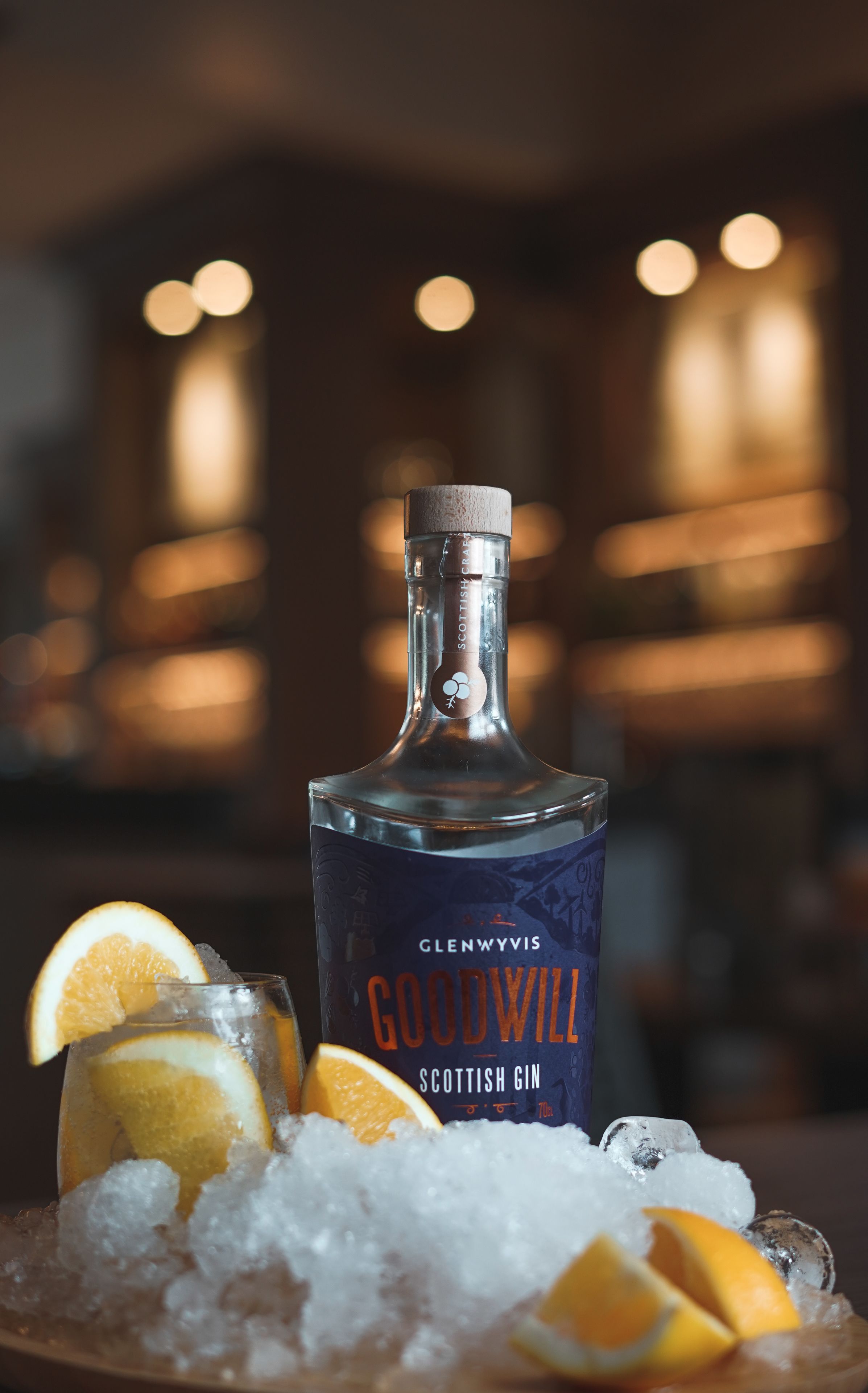 Een fles Glenfiddich Schotse Gin met ijs en oranjeschijfjes op een dienblad.