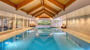 An indoor swimming pool with wooden beams, glass walls, and a view of greenery outside. - Inverness Palace Hotel & Spa, WorldHotels Distinctive (Inverness)