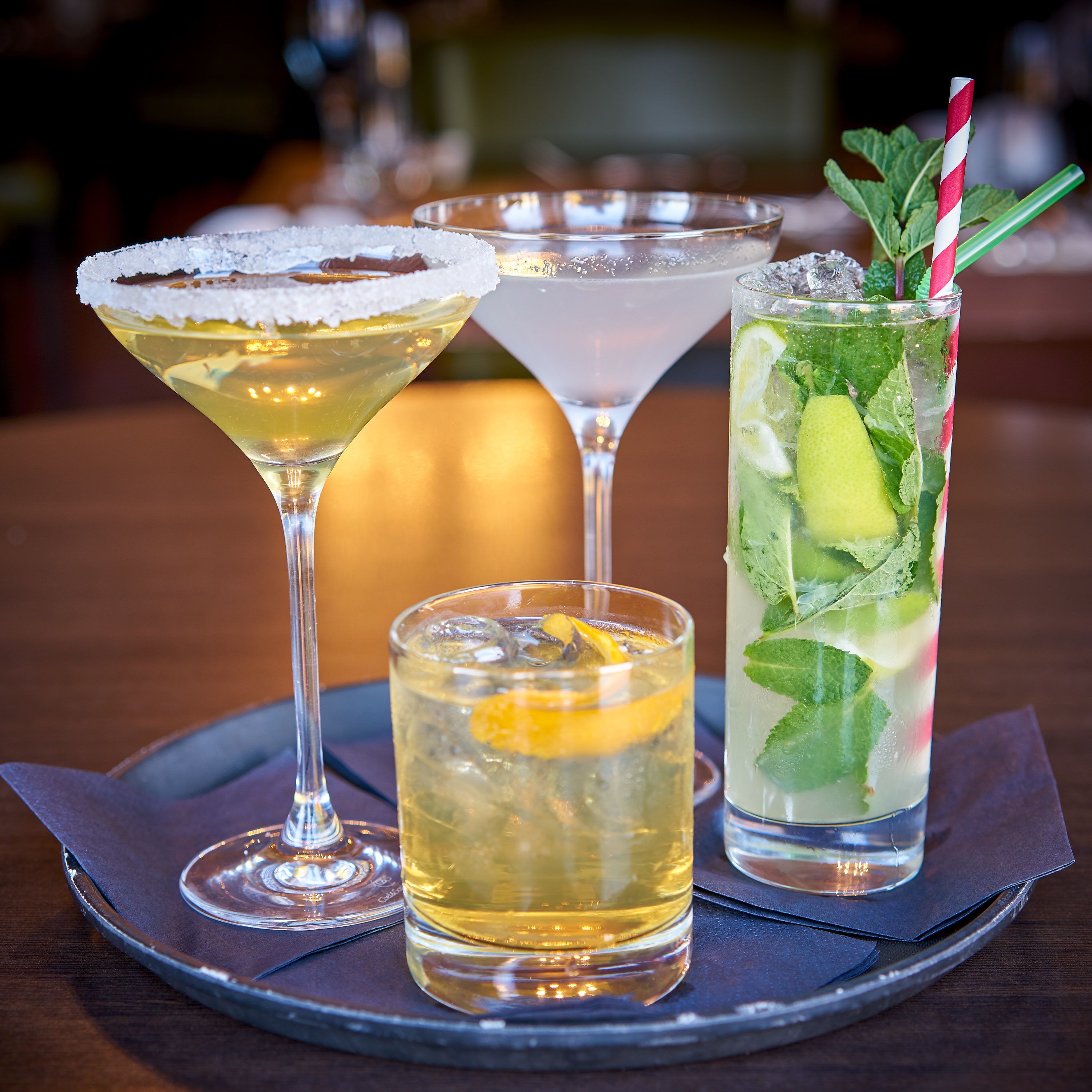 Four different types of drinks on a tray.