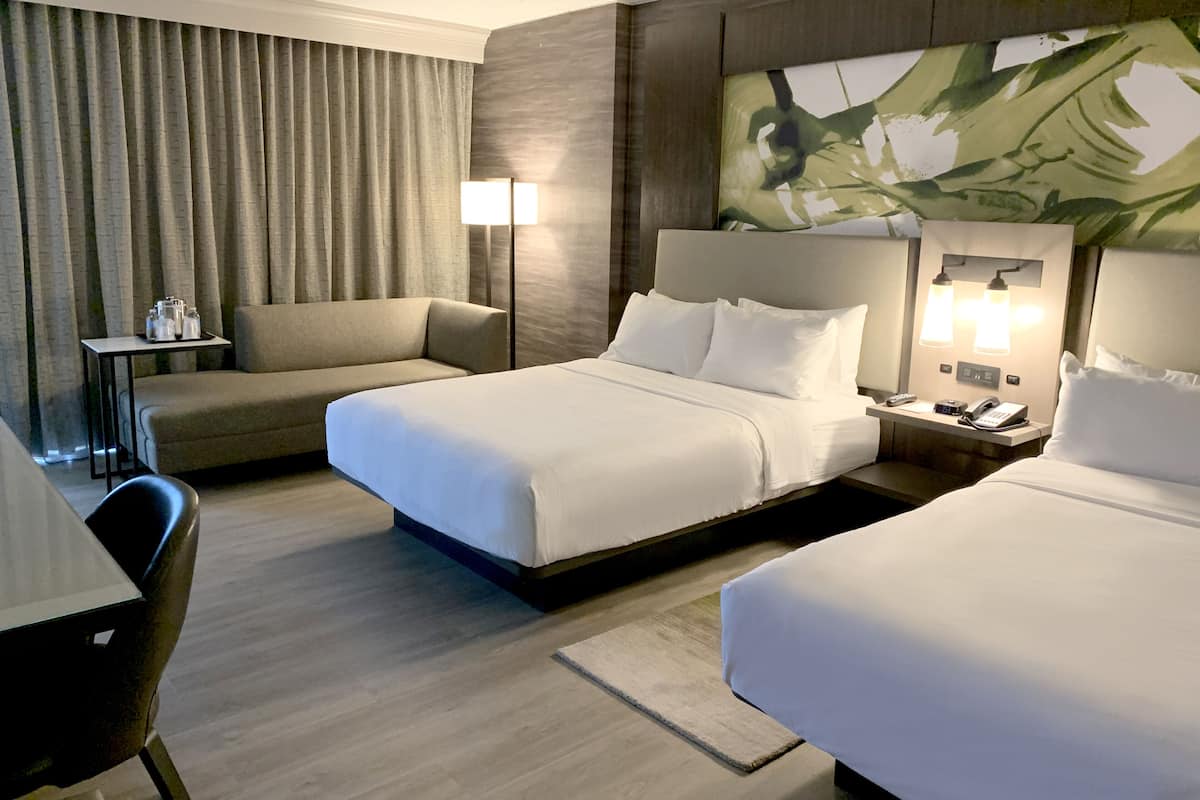 Ein Hotelzimmer mit Bett, Sofa, Schreibtisch und Lampe.