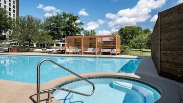 En säsongsöppen utomhuspool, parasoller och solstolar