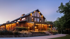 Une maison moderne à deux étages, dotée de grandes fenêtres, d’un porche abrité et d’un éclairage extérieur.