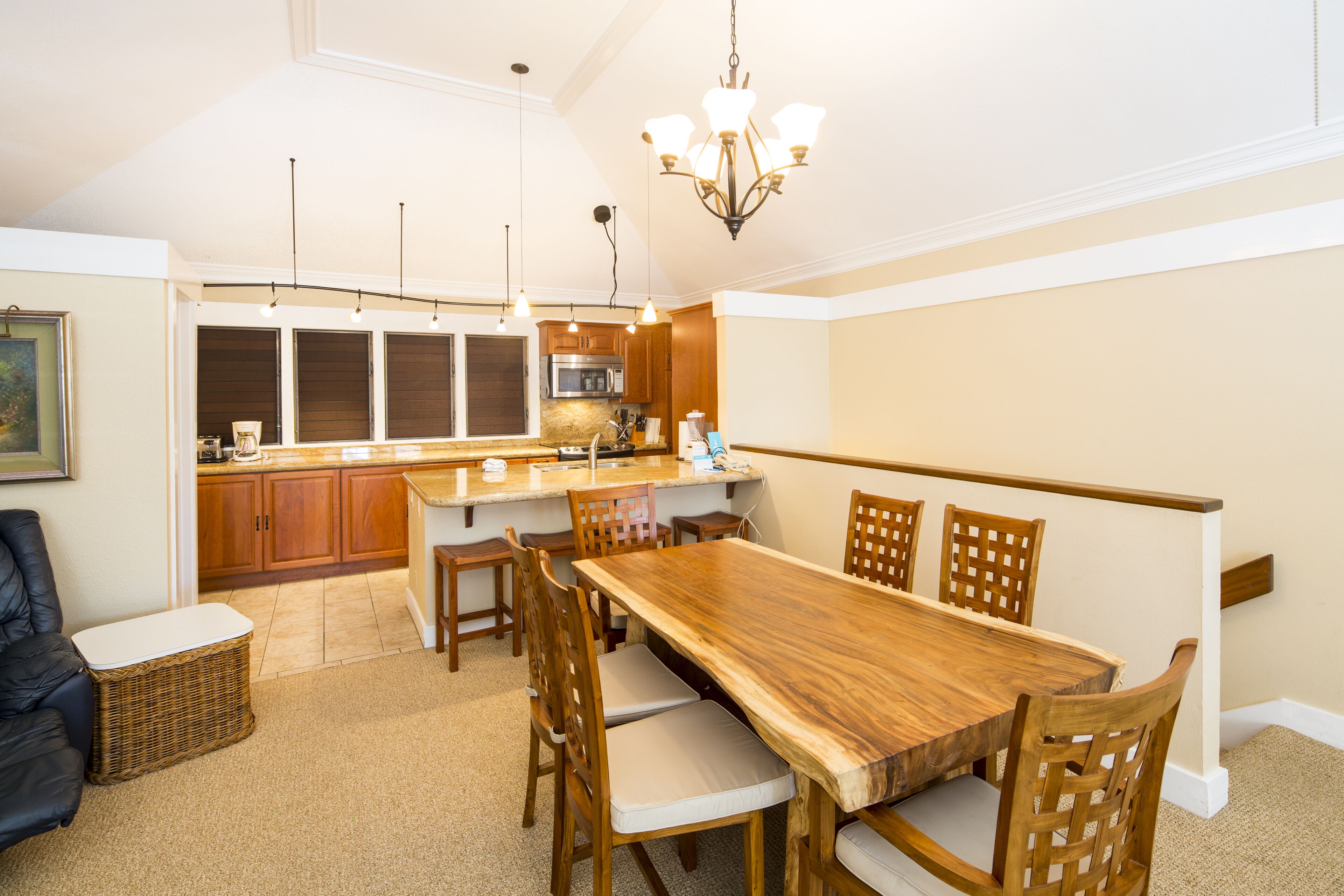 Uma cozinha espaçosa com armários de madeira, uma ilha grande e uma área de jantar com mesa e cadeiras de madeira.