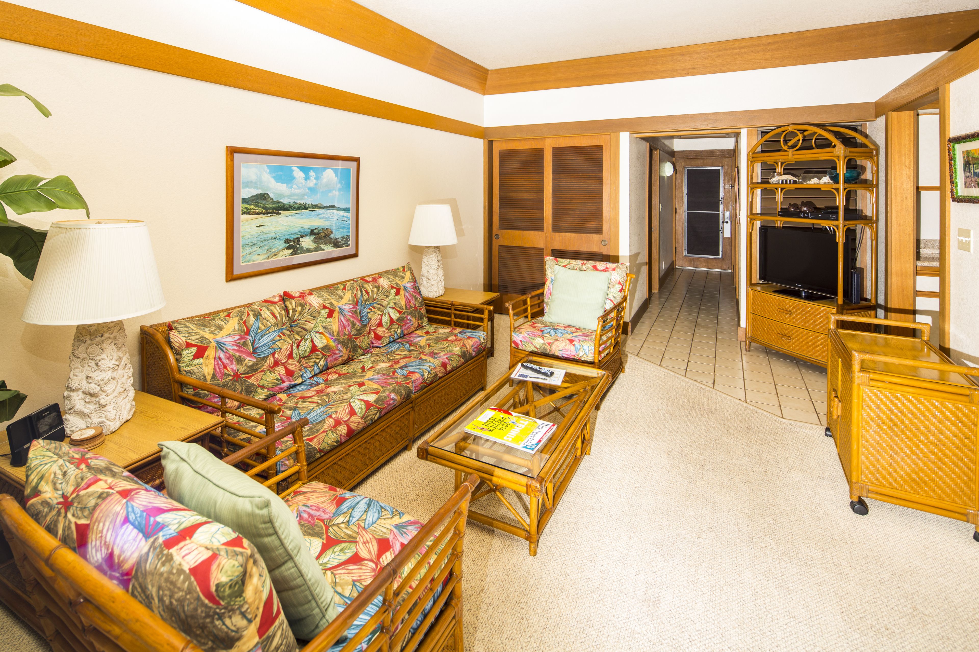 A spacious living area with a sofa, chairs, a coffee table, and a TV stand.