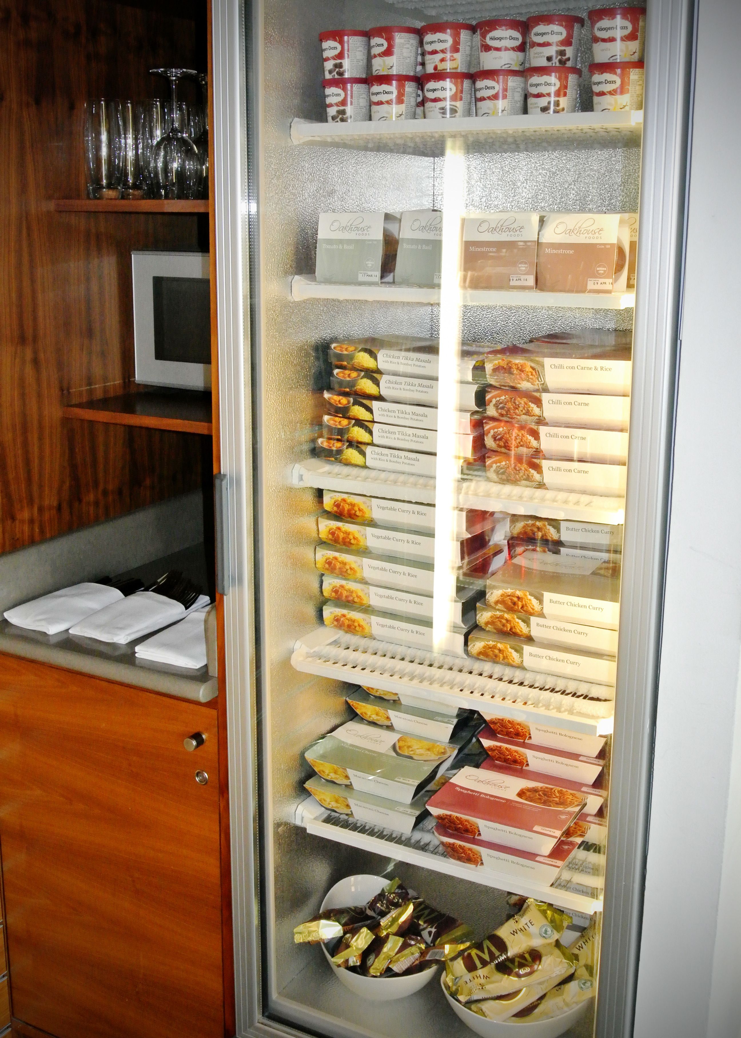 Eine Kühlvitrine mit verschiedenen Lebensmitteln, darunter Fertiggerichte und Gewürzen.