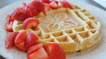 Een wafel met aardbeien op een bord.