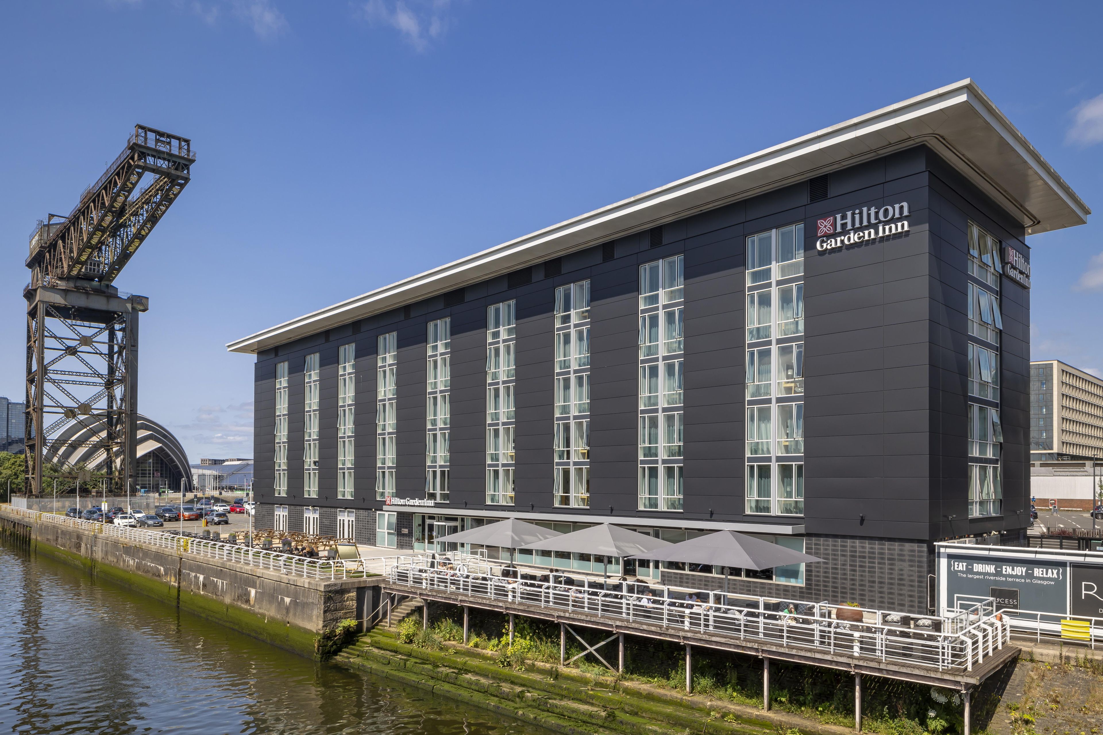 A modern building with a flat roof and large windows, labeled as a Hilton Garden Inn.