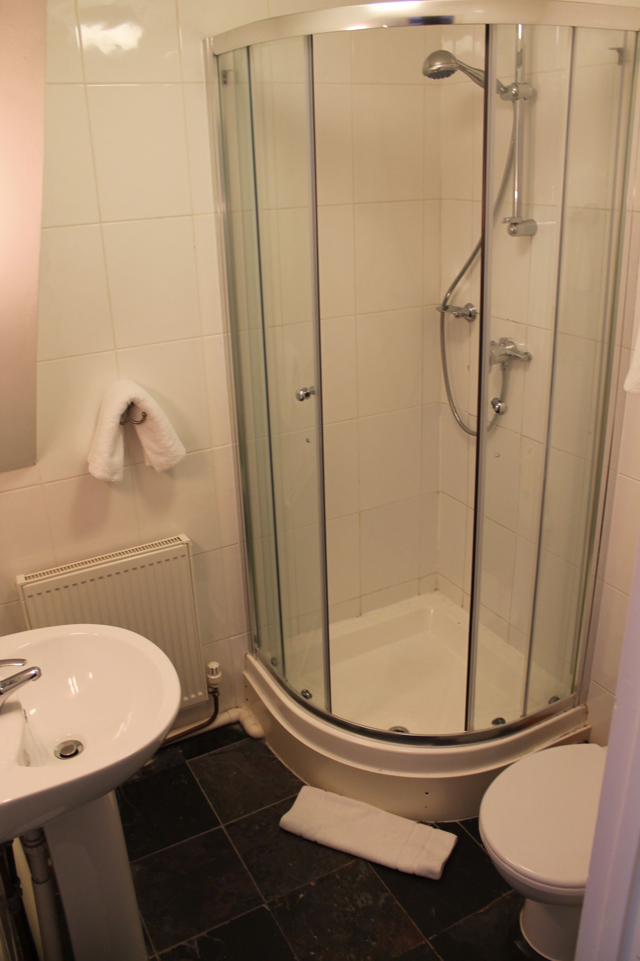 Ein Badezimmer mit Duschkabine, Waschbecken und Toilette.