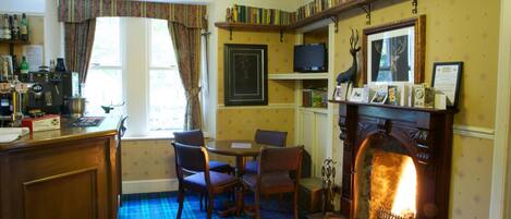 A cozy room with a fireplace, a television, a bookshelf, and a plaid-patterned floor.