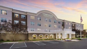 A hotel with a sign reading "Homewood Suites by Hilton," featuring a modern architectural design with a flat roof and multiple windows. - Homewood Suites by Hilton Erie (Erie)