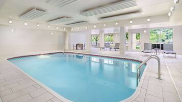 Una piscina techada, sillones reclinables de piscina