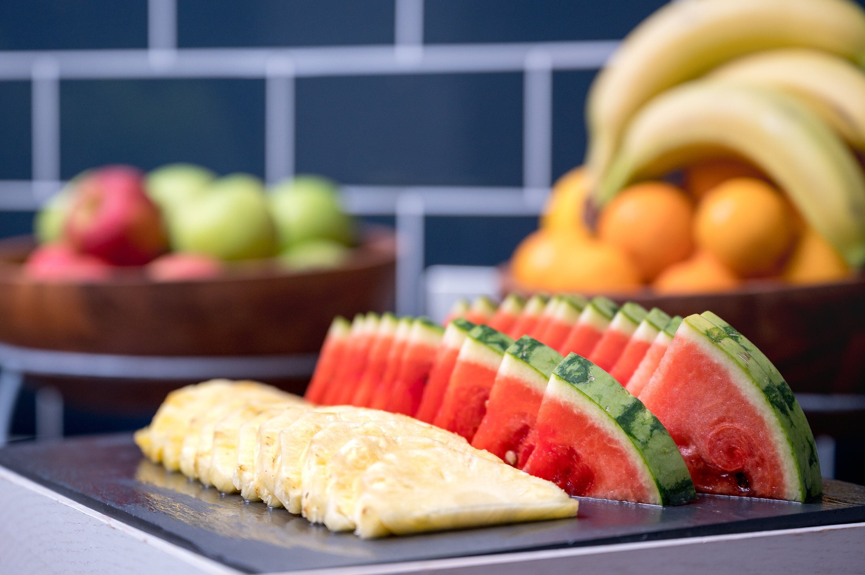 A kitchen counter with sliced watermelon and a banana.
