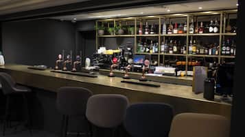 A bar area with stools, a counter, and shelves of liquor bottles.
