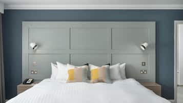 Una habitación de hotel con una cama grande, una mesita de noche y una lámpara fijada a la pared.