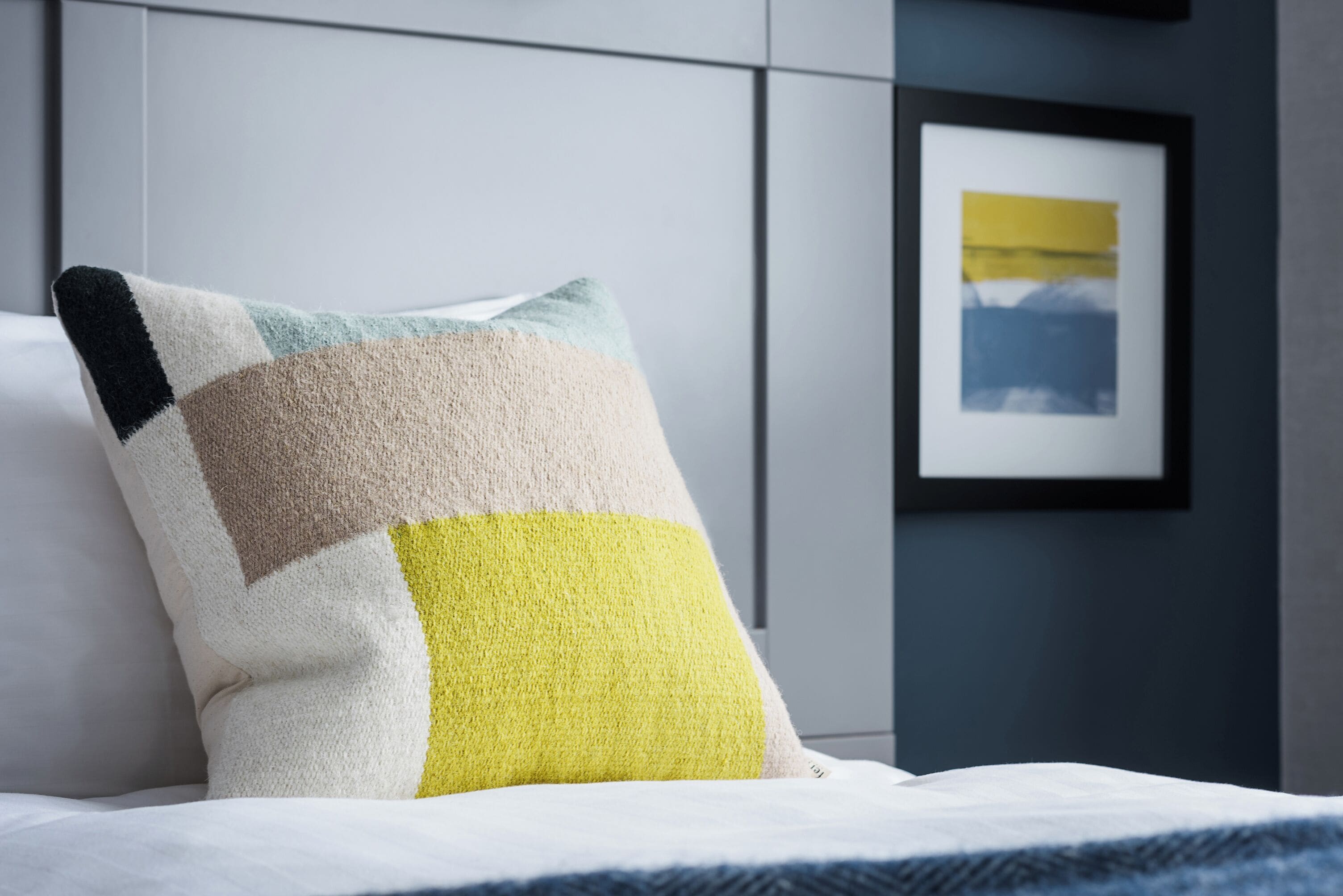 Un lit avec un oreiller orné d’un motif géométrique.