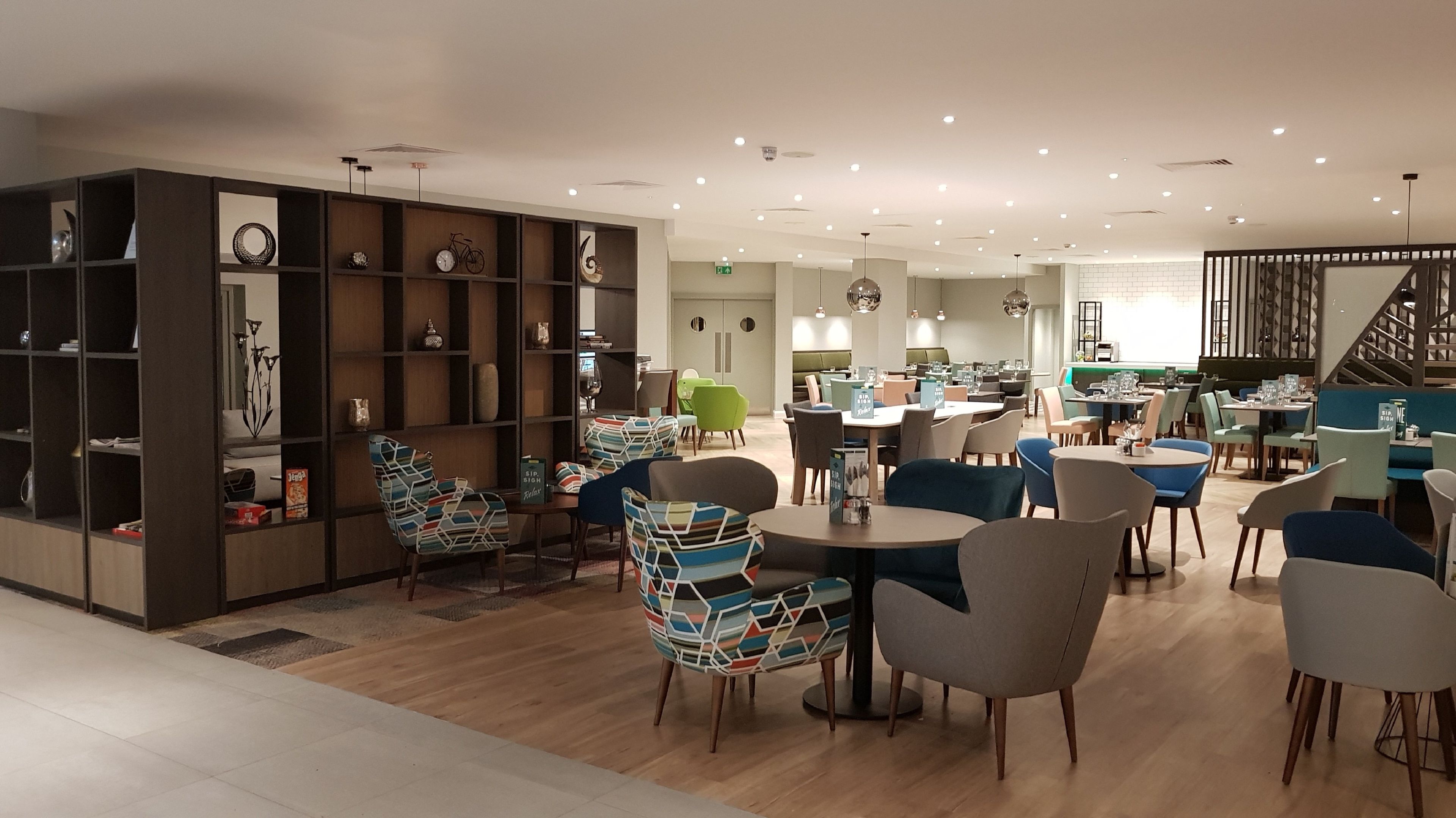 A modern interior with a dining area, seating, and a staircase.