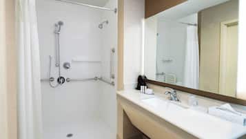 A modern bathroom with a walk-in shower, a sink with a mirror, and a towel rack.