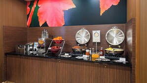 Un mostrador de buffet con diferentes alimentos y electrodomésticos de cocina.