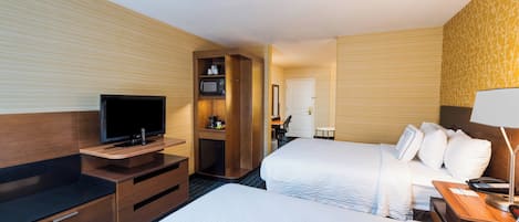 A hotel room with two beds, a TV, a desk, and a microwave.