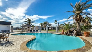 A swimming pool with a curved edge, surrounded by palm trees and a gazebo. - Best Western Port Lavaca Inn (Port Lavaca)