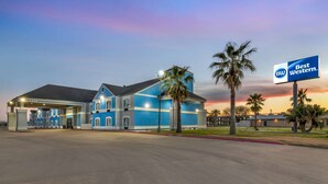 A Best Western hotel with a blue facade, a gas station, and palm trees. - Best Western Port Lavaca Inn (Port Lavaca)