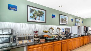 A breakfast buffet with various food items, a microwave, and a coffee maker. - Best Western Port Lavaca Inn (Port Lavaca)