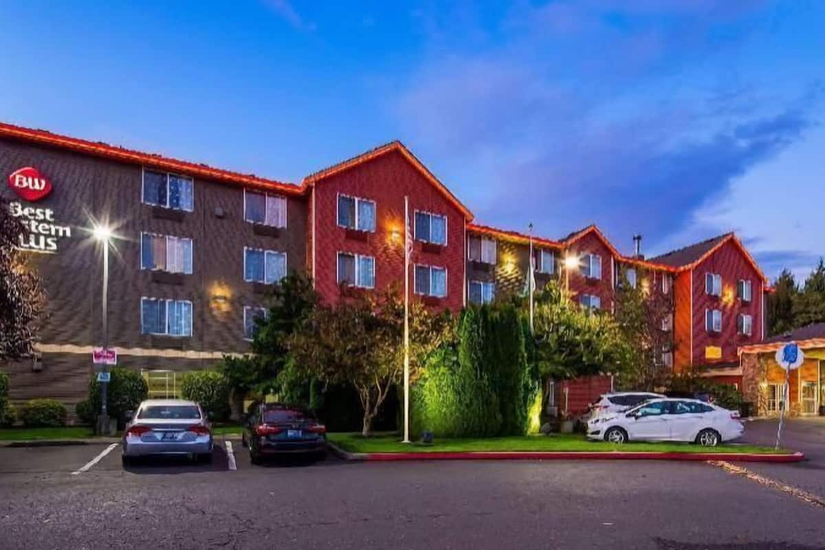 Un hotel de varios pisos, un estacionamiento y un letrero de Best Western Plus.