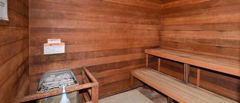 Una sauna con bancos de madera y un banco con perchero.