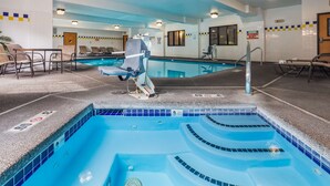 Una piscina interior con una silla de salvavidas, sillas de descanso y un cartel que indica que no hay salvavidas de servicio.