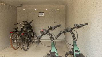 Ein Fahrradstellplatz mit zwei Fahrrädern und einem grünen E-Bike.