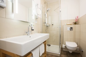 A modern bathroom with a large sink, a glass shower enclosure, and a toilet. - Best Western Plus Theodor Storm Hotel (Husum)
