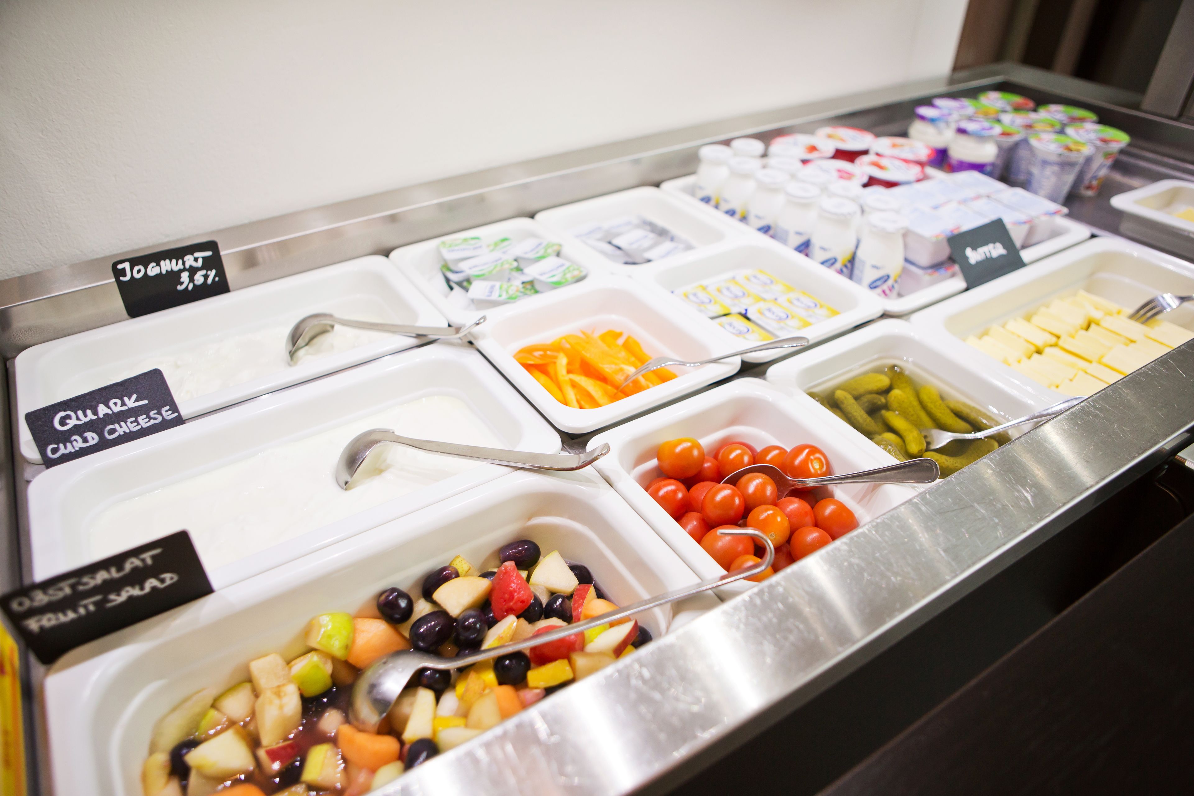 En buffé med tydligt avgränsade sektioner för yoghurt, kvarg, fruktsallad och diverse andra rätter.