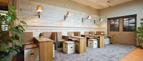 Una habitación con muebles de madera, alfombra gris y lámparas de pared.