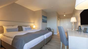 Una habitación de hotel con una cama, un escritorio, una silla y un televisor.