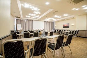 A conference room with multiple tables and chairs, a whiteboard, and a painting on the wall. - Best Western Plus Theodor Storm Hotel (Husum)